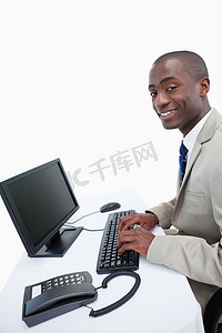 行政文员摄影照片_使用电脑的微笑商人的侧视图