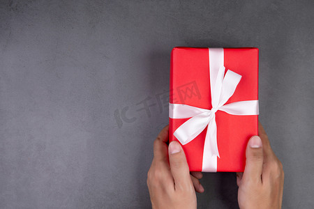 圣诞节或假期，男人的手拿着礼物在水泥地板上送礼，周年纪念或生日礼物盒，或带有复制空间的庆祝活动，庆祝和节日，顶视图，平躺。