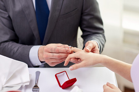 男人把戒指戴在未婚夫手指上的特写