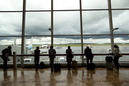 机场的乘客在 airf 等候并看着窗外