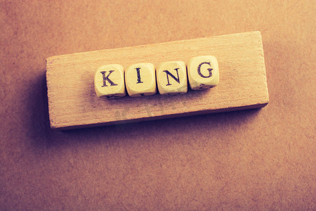 国王加冕摄影照片_国王在木头上用木立方体写字