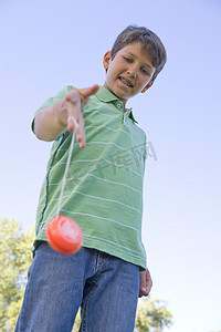 小男孩在户外微笑着使用溜溜球