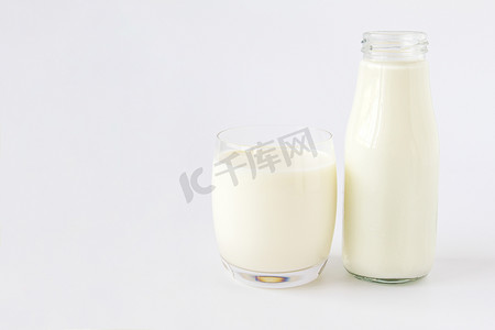 白色背景中的一瓶牛奶和一杯牛奶