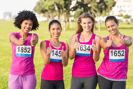 四位微笑的赛跑者支持乳腺癌马拉松