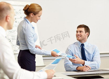 微笑的女人在办公室里给男人递文件