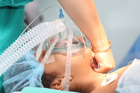 麻醉摄影照片_护士为一名身份不明的病人准备氧气面罩