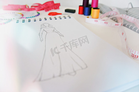 创意时尚摄影照片_时尚服装设计草图在工作室。