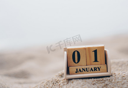 签到月历摄影照片_木砖块显示 1 月 1 日或元旦的日期和月历。