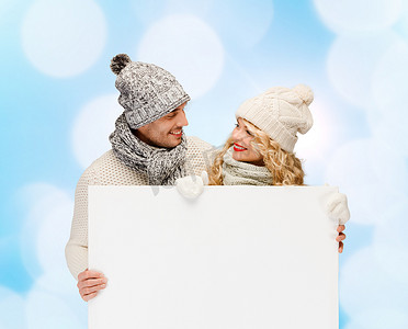 穿着冬装、拿着白板微笑的情侣