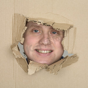 有趣纸盒摄影照片_孔纸盒中的男性面孔
