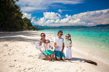 年轻快乐的四口之家在热带度假，带着“爱”这个词