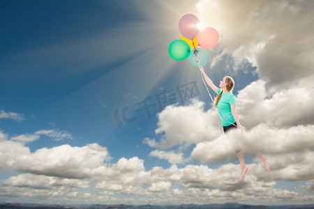 年轻的成年女性被她拿着的气球带上云层。