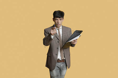 一位年轻商人在彩色背景上拿着剪贴板指着的肖像