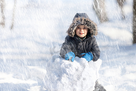 在冬季公园玩雪的可爱男孩