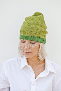 圣诞节绿色帽子摄影照片_温暖的绿色帽子的美丽的少妇。
