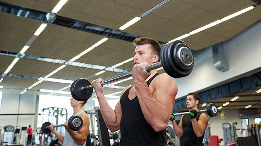 一群男人在健身房用杠铃锻炼肌肉