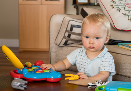 在桌上玩玩具电脑的婴儿白人男孩