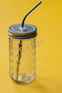 玻璃杯中的生态天然金属吸管，用于饮料，可持续生活方式的概念。