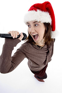 带麦克风和圣诞帽的青少年歌手