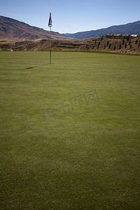 有绿草和清楚的蓝天的高尔夫球场。