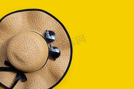 带太阳镜的夏季帽子在黄色背景上。