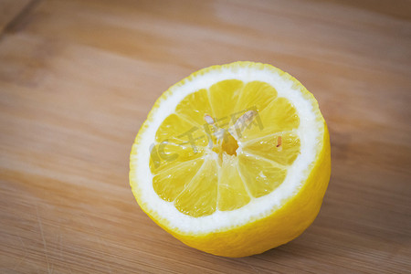 浅色木板摄影照片_浅色木板上的半个柠檬