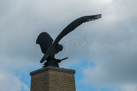 在阴云密布的天空中张开翅膀的老鹰雕像