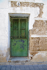 白色木门摄影照片_有纹理的白色墙壁，绿色木门