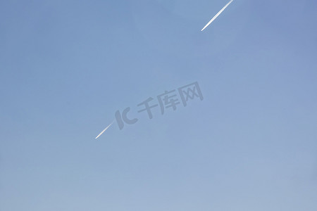 飞行痕迹摄影照片_飞机在天空留下的喷气燃料痕迹