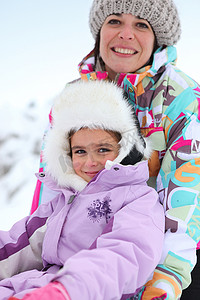 母亲和女儿坐在雪地里