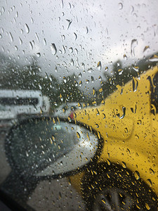 有汽车的路通过汽车的雨飞溅的挡风玻璃被拍摄