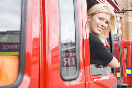 女消防员摄影照片_女消防员坐在消防车里，头朝窗外