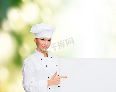 白色冲浪板摄影照片_有白色空白板的微笑的女性厨师