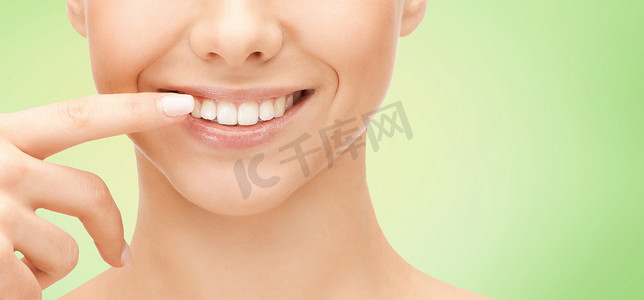 微笑的女人脸指着牙齿的特写