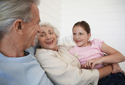 代沟摄影照片_快乐的祖父母和孙女坐在沙发上