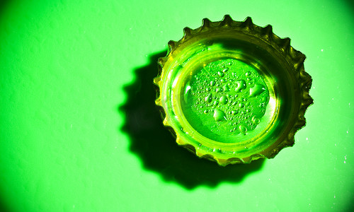 水晕摄影照片_绿色带水滴的啤酒盖