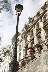 活动指南指南摄影照片_一对微笑的夫妇带着指南从桥上看的低角度视图