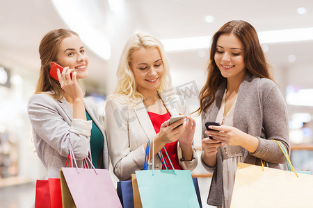 手机购物商城摄影照片_拿着智能手机和购物袋的快乐女人