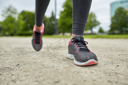 在公路上奔跑摄影照片_从后面在轨道上奔跑的女人脚的特写