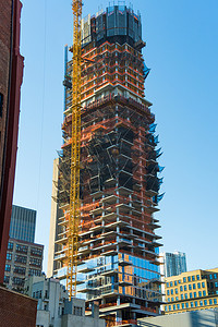 黄色建筑背景摄影照片_纽约市中心黄色建筑起重机的建筑景观