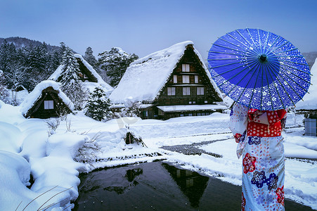 冬季女性摄影照片_冬季，日本联合国教科文组织世界遗产白川乡穿着日本传统和服的亚洲女性。