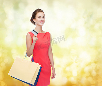 塑料卡摄影照片_带着购物袋和塑料卡的微笑女人