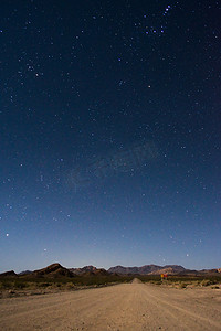 浩瀚宇宙摄影照片_阿根廷门多萨乌斯帕亚塔附近一条穿过沙漠的土路上方繁星点点的夜空。