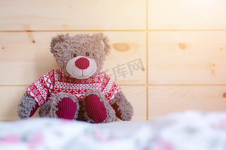 泰迪梦的概念：泰迪熊坐在一张木床上，阳光下