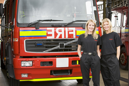 女消防员摄影照片_站在消防车旁的两名女消防员的画像