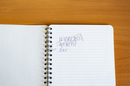 木桌上有文字世界健康日的记事本、健康概念、极简主义风格的复制空间