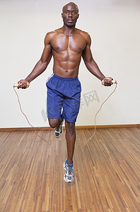 集体跳绳摄影照片_赤膊肌肉男在健身房跳绳