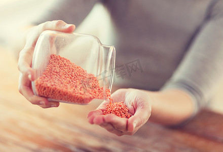 红状摄影照片_关闭装有红扁豆的女性倒空罐