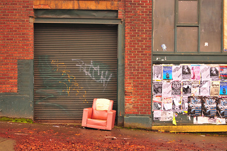 砖墙、海报和破烂的红色椅子