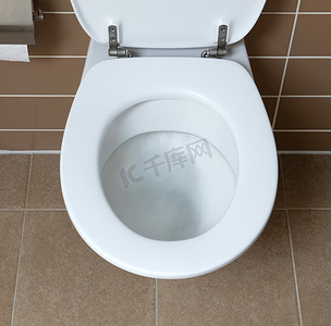 厕所标语冲水摄影照片_浴室里的白色马桶，冲水